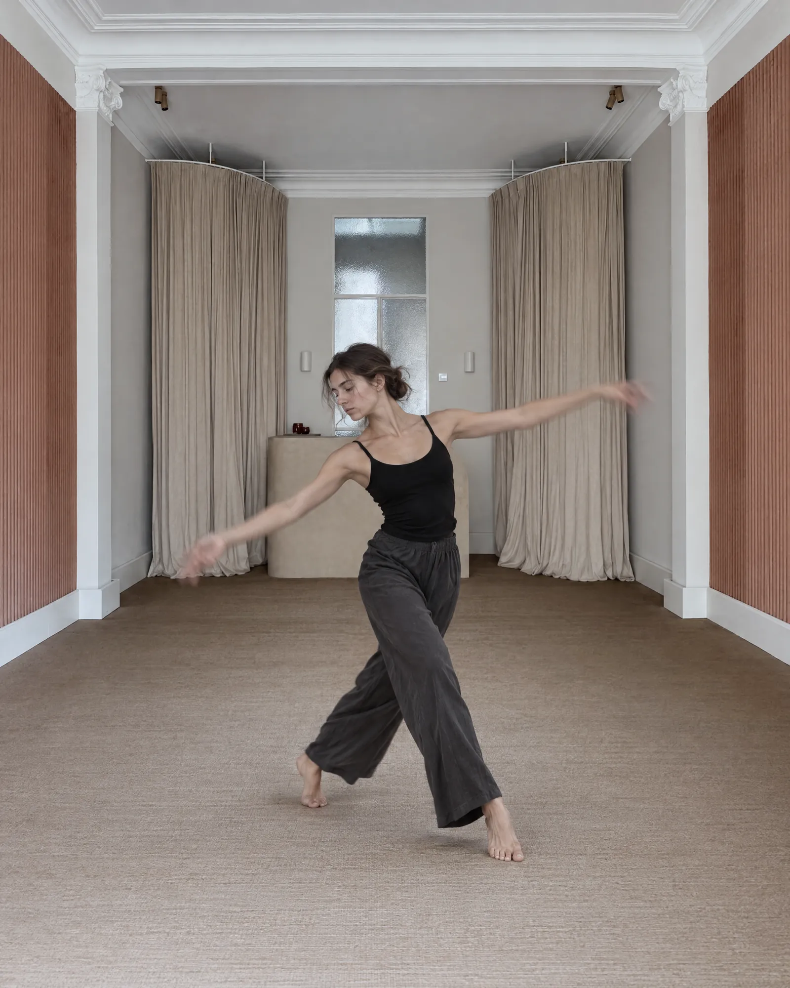 Een jonge danser in een vloeiende beweging in de lichte salon van Huis Pollet