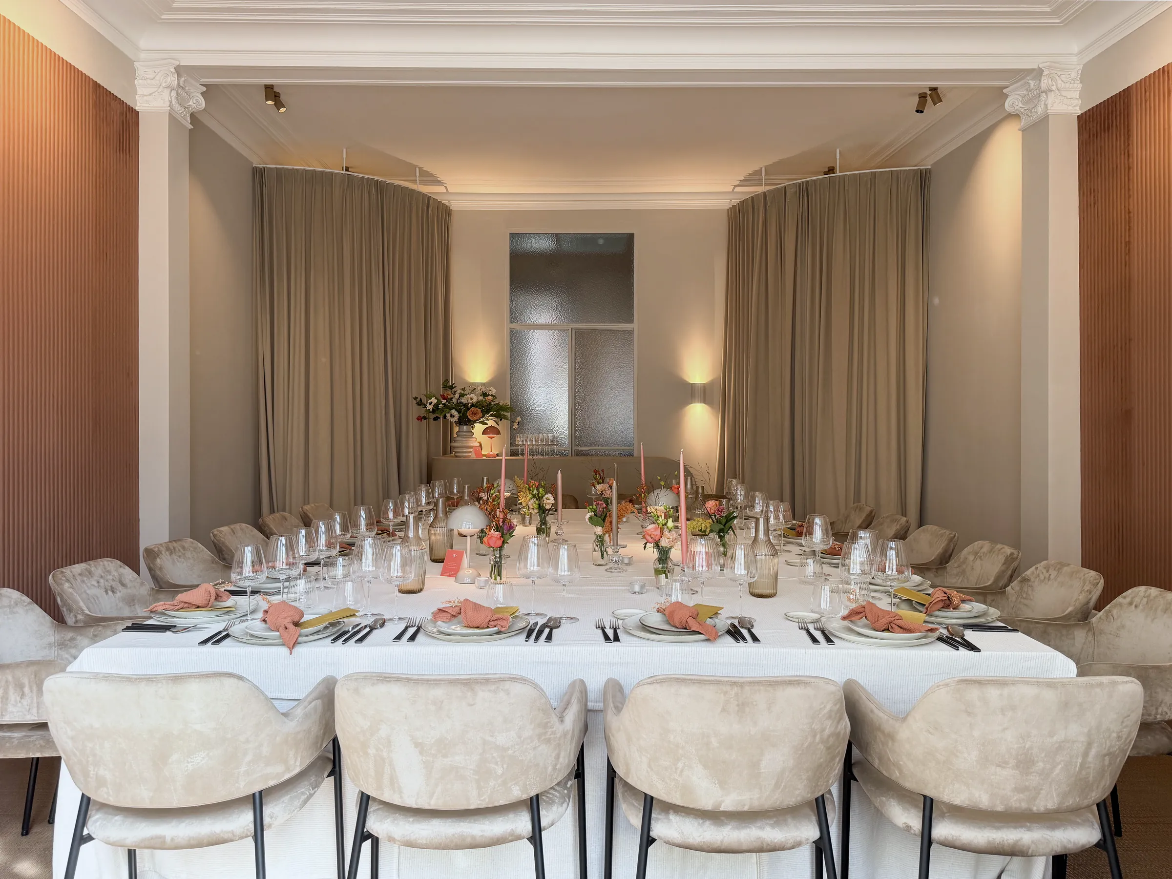 De salon van Huis Pollet gedekt voor een privédiner: lange tafel, fluwelen stoelen, bloemen en kaarsen